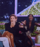 a man and a woman are sitting on a couch and the woman is laughing .