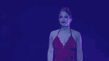 a woman in a red dress is standing next to a man in a blue suit on a stage .