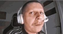 a man wearing headphones and a microphone is looking at the camera .