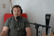 a man wearing headphones is sitting in front of a microphone ..