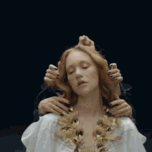 a woman in a white dress is being held by a man with black nails