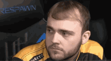 a man with a beard is wearing a yellow and black jacket with the word heet7 on it