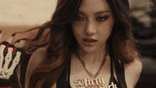 a woman wearing a necklace that says dirty dark on it