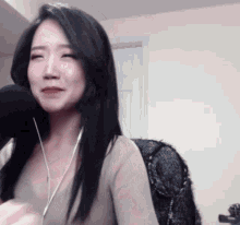 a woman wearing headphones and a microphone looks at the camera
