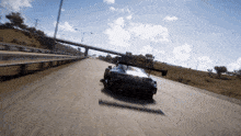 a black sports car is driving down a highway under a bridge