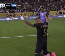 a soccer player with the number 5 on his back kneeling on the field