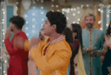 a man in a yellow dress is dancing in front of a crowd