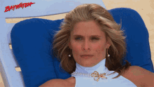 a woman sits in a beach chair with the word baywatch on the back