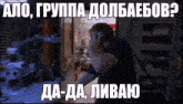 a man talking on a cell phone in a dark room with russian writing on it