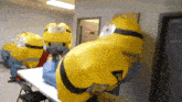 a group of inflatable minions are sitting on a table in a room