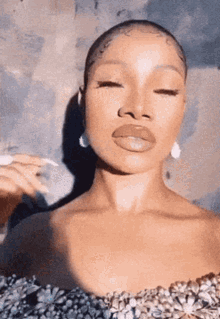 a close up of a woman 's face with her eyes closed and earrings