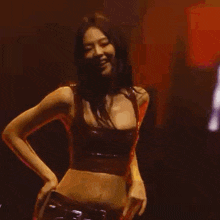 a woman is dancing in a dark room with her eyes closed and her tongue out .