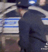 a police officer is standing next to a police car .