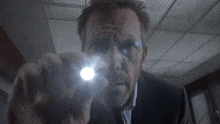 a man is holding a flashlight in front of his face