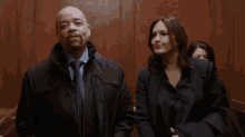 a man and woman are standing next to each other in an elevator .