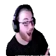 a man with a beard and glasses is wearing headphones and making a funny face .