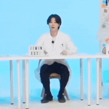 a person is sitting at a table with their arms outstretched .