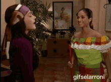 two women standing next to each other in a living room with a gifselaroni watermark