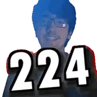 a man with glasses is smiling and holding up the number 224
