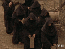 a group of monks wearing hoods and holding wooden boards with the words wheel written on the bottom