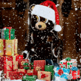 a teddy bear wearing a santa hat stands in front of a pile of gifts