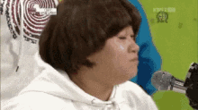 a blurry picture of a person talking into a microphone with kbs2 on the bottom left
