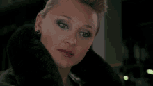 a close up of a woman wearing a black fur coat