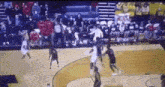 a basketball game is being played on a court with a crowd watching .