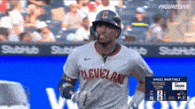 a baseball player wearing a cleveland uniform is running