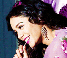 a woman in a purple dress is holding a lollipop in her mouth