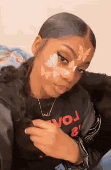 a girl with butterflies painted on her face wears a shirt that says vol 2