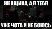 a woman in a black dress is standing in front of a window with a caption in russian