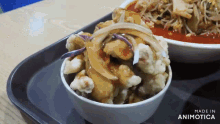 a bowl of food on a tray with the words made in animotica below it