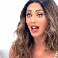a woman with long hair is making a surprised face with her mouth open