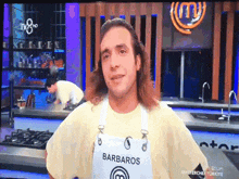 a man with long hair is wearing an apron that says barbaros on it
