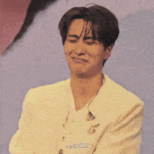 a man wearing a white jacket is making a funny face with his eyes closed