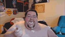 a man in a room with a man cave sign behind him