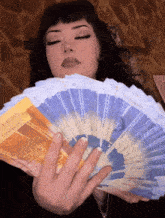 a woman is holding a fan of money that says ' switzerland ' on the front