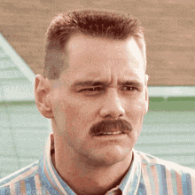 a man with a mustache is making a funny face .