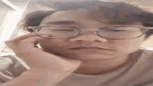 a close up of a person wearing glasses covering their face .