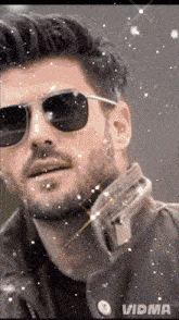 a man with a beard wearing sunglasses and a jacket