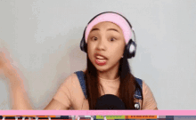 a young girl wearing headphones and a pink headband