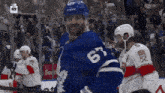 a hockey player with the number 63 on his jersey stands on the ice