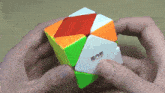 a person is holding a colorful cube with chinese writing on the side
