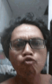 a man with glasses is making a funny face .