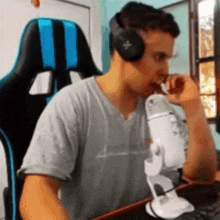 a man wearing headphones is sitting in front of a microphone and eating something .