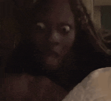 a person is laying on a bed in a dark room in a bedroom .