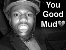 a black and white photo of a man wearing a helmet with the words you good mud below him