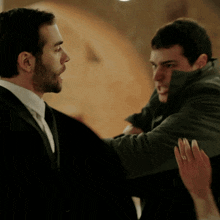 a man with a ring on his finger is holding another man