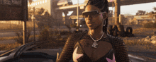 a woman wearing sunglasses and a necklace with the letter bc on her chest